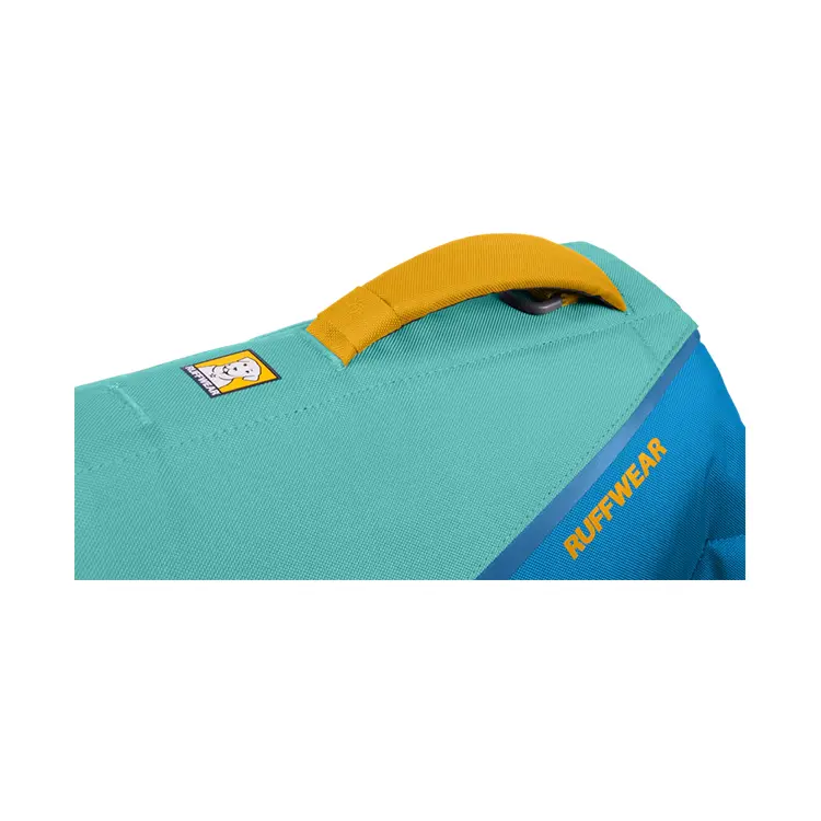 A close-up of the Dog Life Jacket in turquoise and blue shows RUFFWEAR on the side. It features a yellow handle on top and a small logo with a dogs face on the turquoise section.